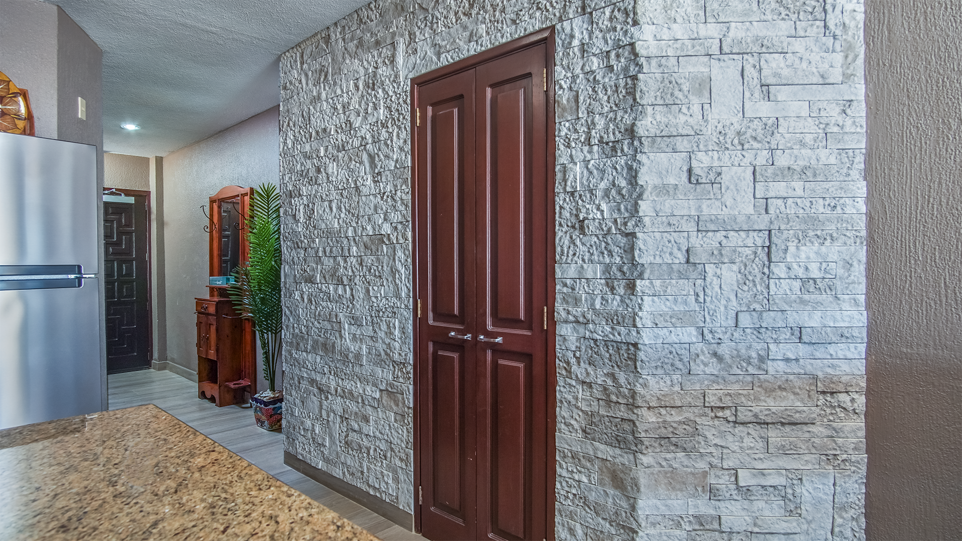 The wall between the kitchen and the entry hall is highlighted by fine stone detail.