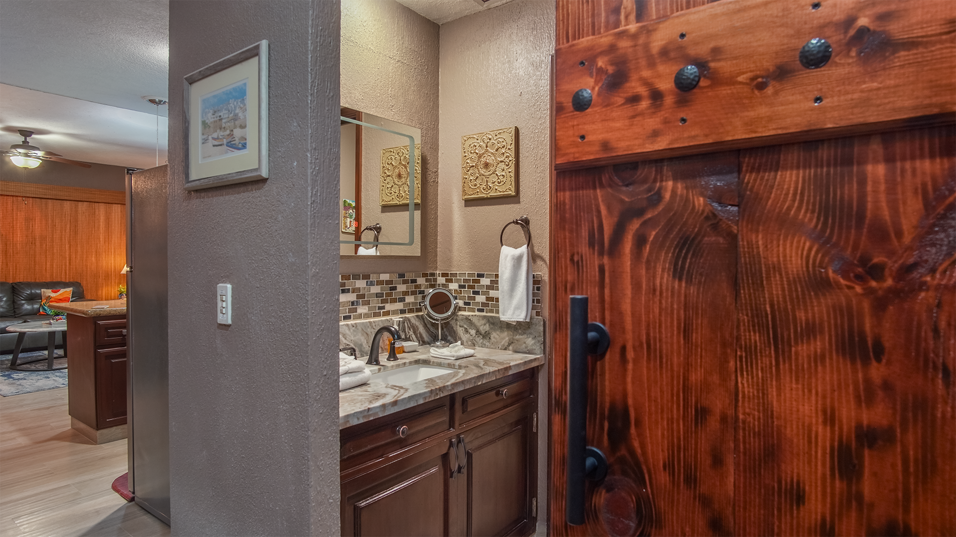 Custom wooden sliding barndoor as you access the bathroom vanity area.