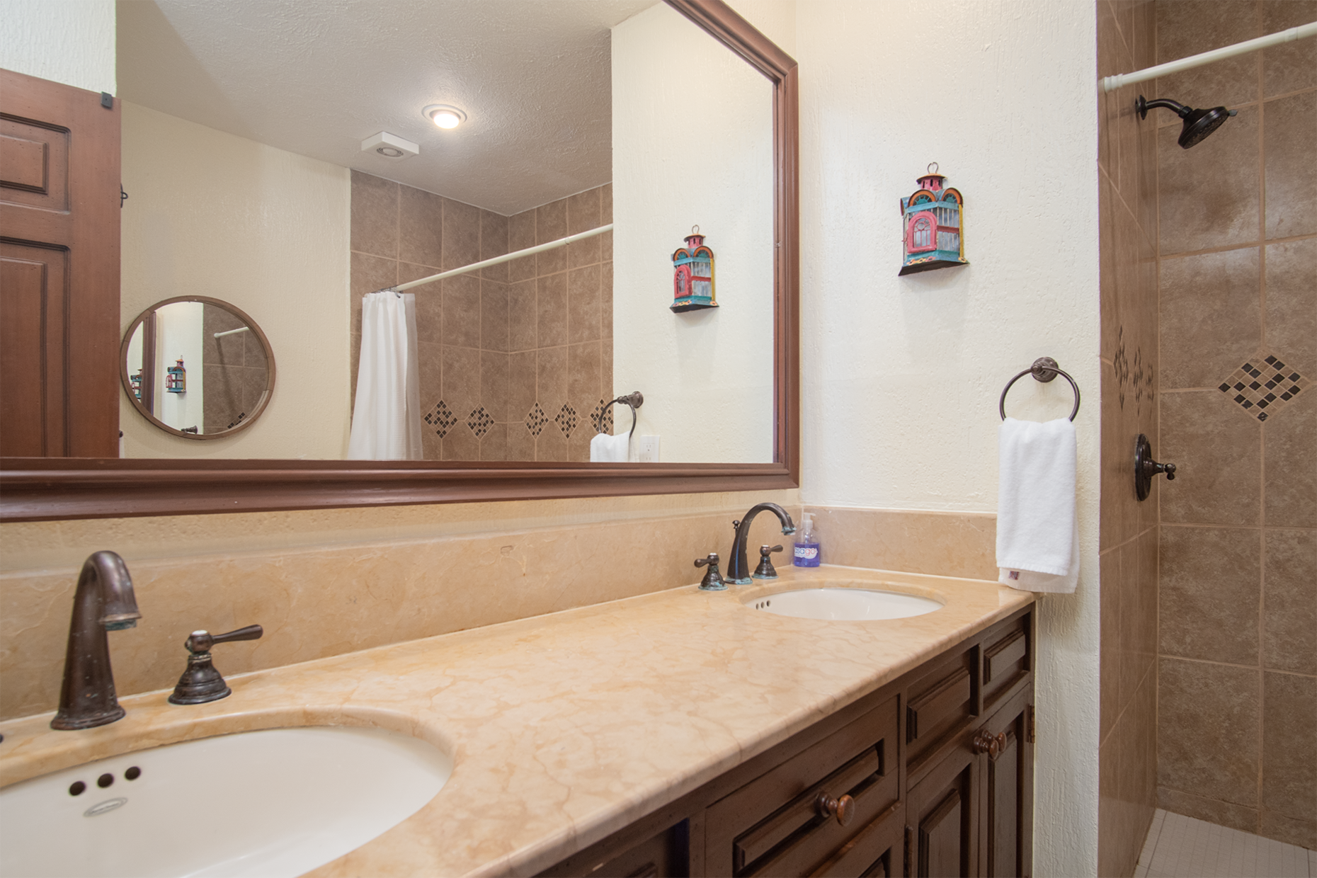main bathroom with double sink vanity and shower stall