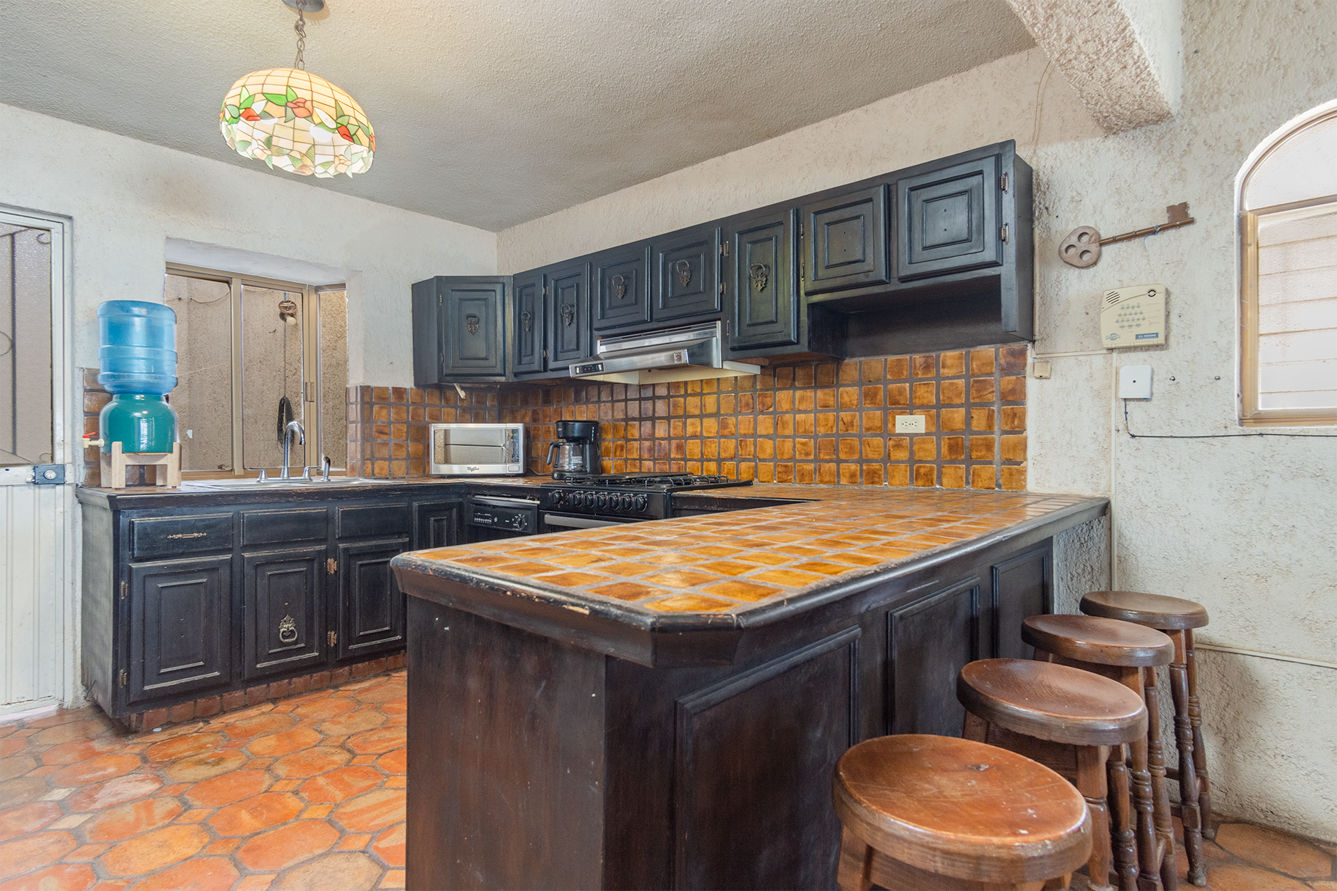 The kitchen has a long counter with stools