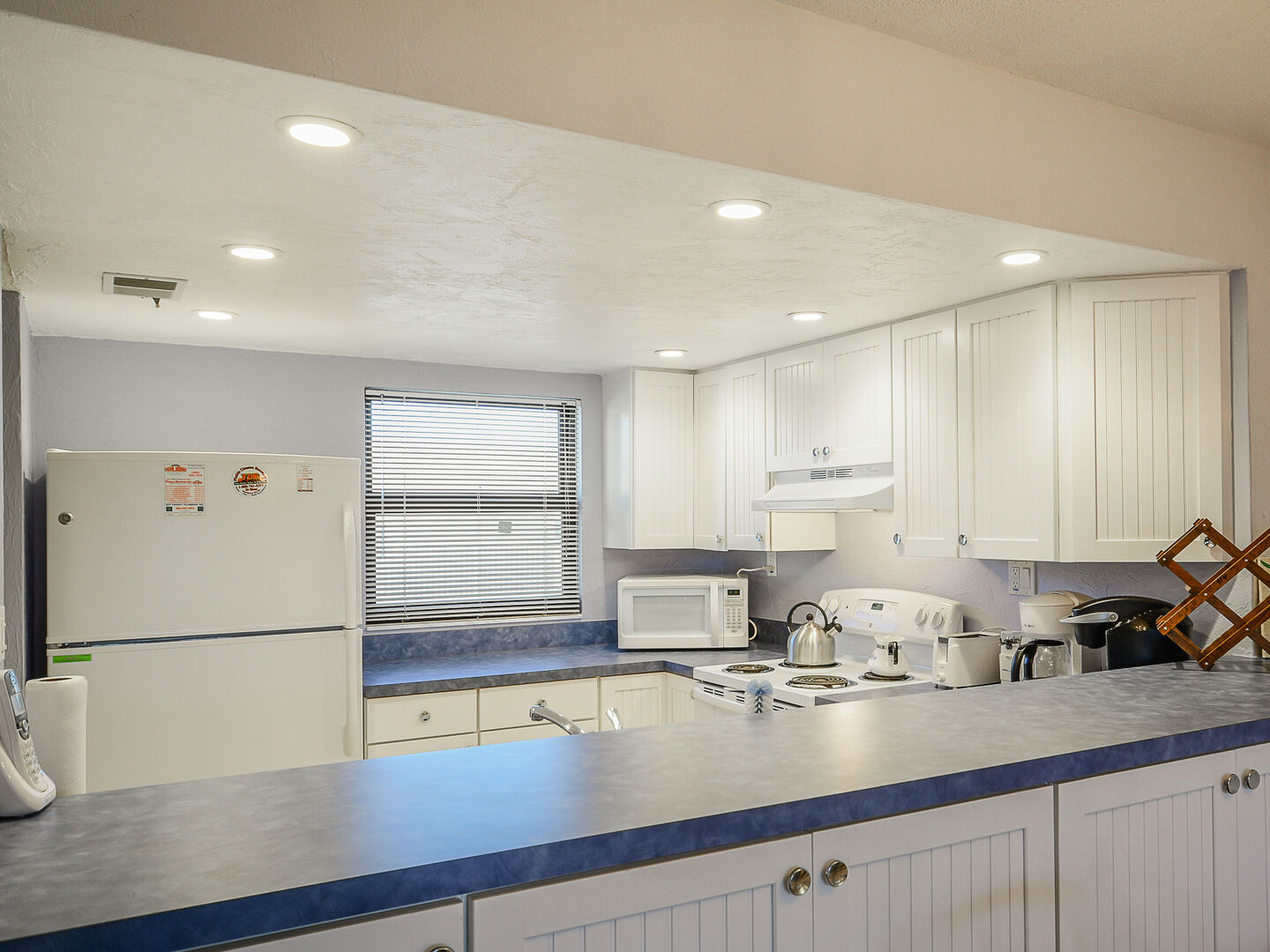 Full Kitchen with Blue Counter Tops and White Cabinets at Castle Reef 516