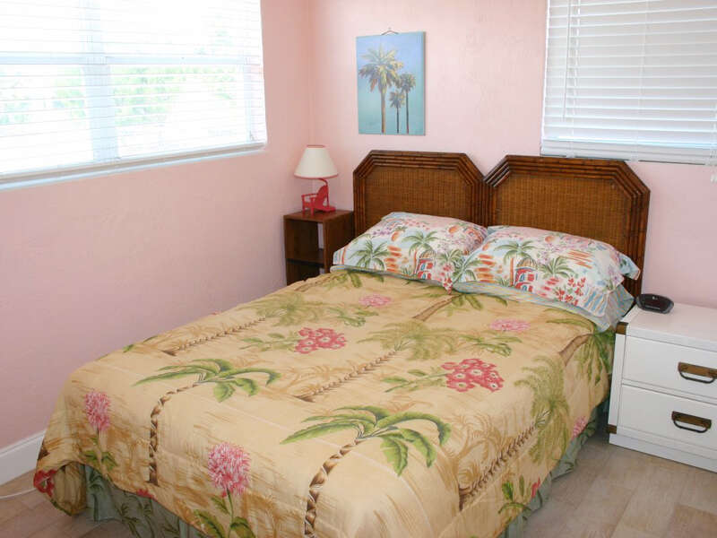 Bedroom with Full Size Bed and Tropical Decorations and Wooden Headboard