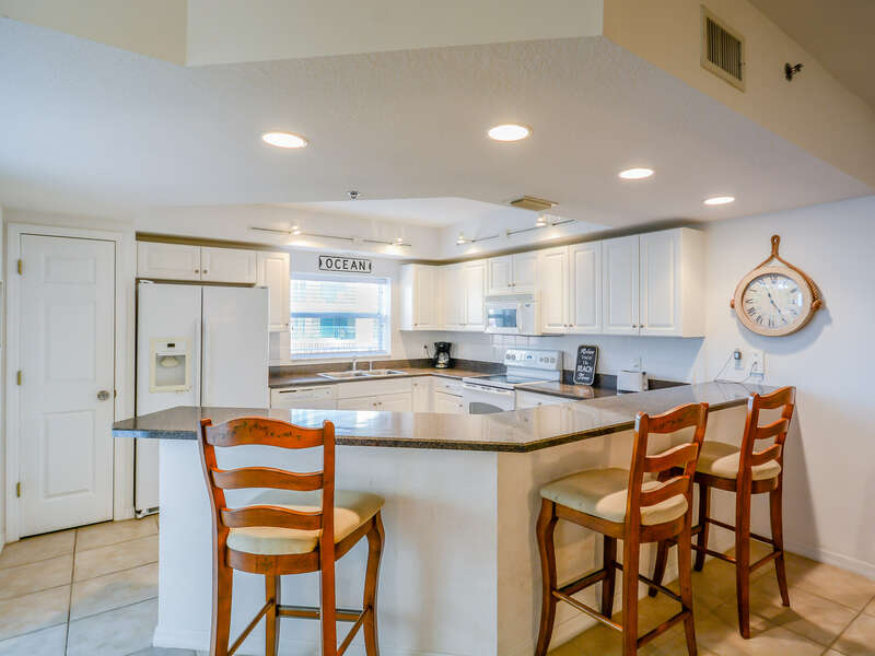 Fully equipped kitchen with additional seating for 3 at the kitchen counter.