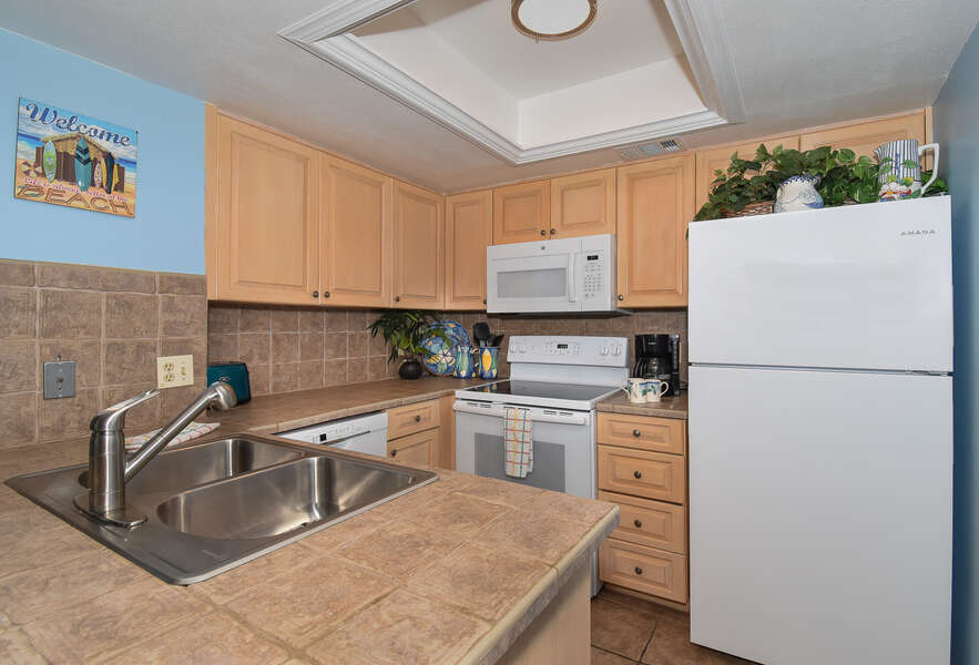 Full Kitchen with White Appliances and Plenty of Storage at New Smyrna Beach Vacation Rentals