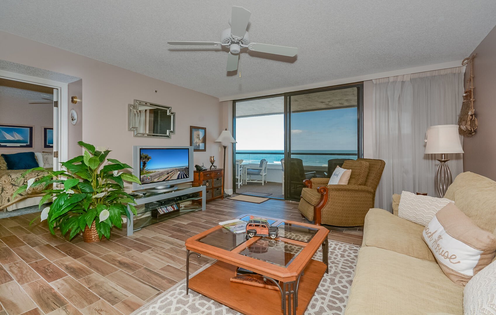 The oceanfront living room of this New Smyrna Beach rental with a flat-screen TV,  DVD player, and sofa sleeper.