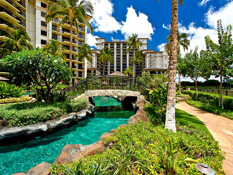 One of the Walkways through the Property leading to this Ko Olina beach villas in Hawaii, with a bridge over a river and island landscaping.