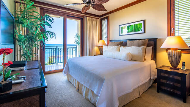 The Ko Olina Beach Villa's Master Bedroom with a King Size Bed, Lanai Access, Ceiling Fan & TV
