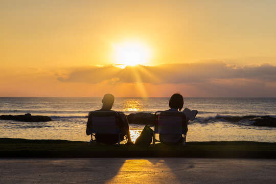 Picture of Two People Seating on the Lagoons at the Sunset.