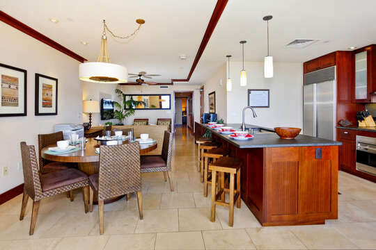 Kitchen with Island, Stools, Dining Table, Chairs, Refrigerator, and Ceiling Lamps.