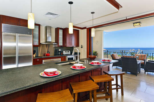 The Kitchen with Island, Stools, Balcony Chairs, and the Ocean View.