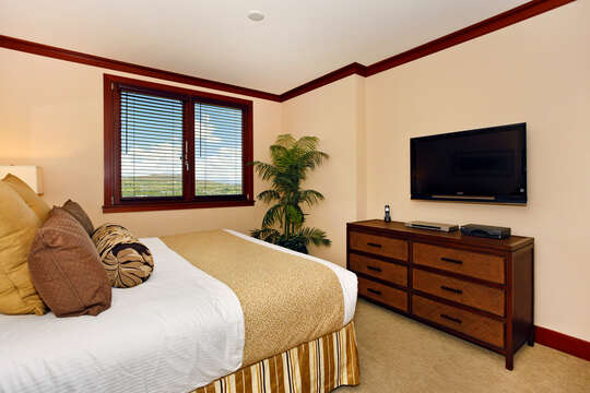 Bedroom with Large Bed, Drawer Dresser, and TV.