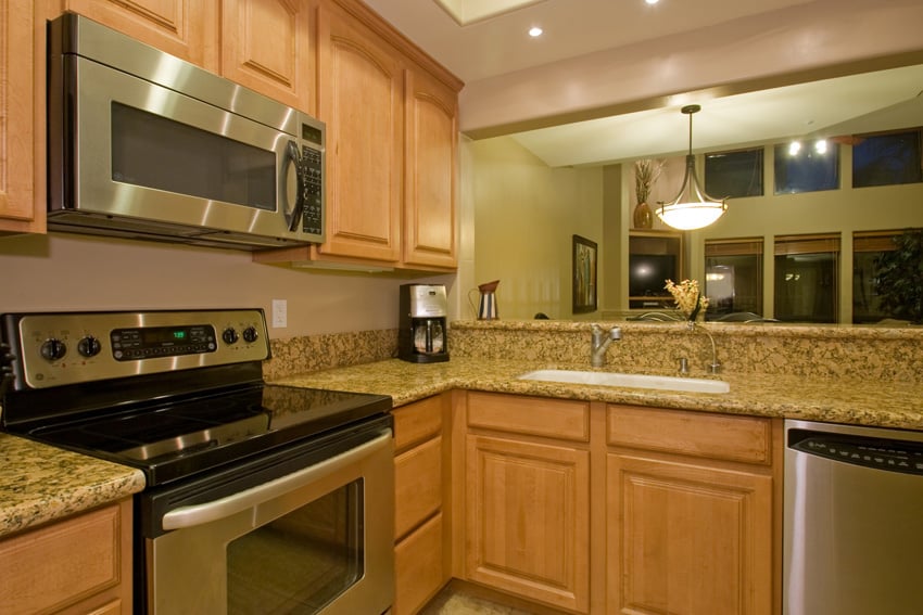 Kitchen has stainless steele appliances and slab granite counters