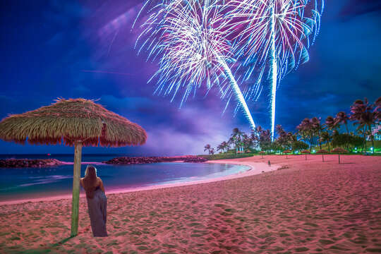 Woman under Beach Cabana Watching Fireworks on the Ko Olina Lagoon.
