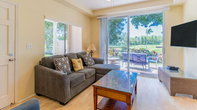 The Living Area of this Ko Olina condo rental with a View to the Golf Course, ample seating, and a TV.