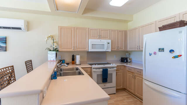 Large, Open Kitchen with fridge, extended counter-tops with bar seating, and oven.
