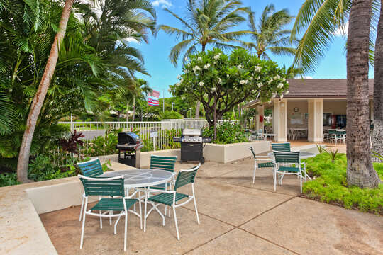 Tables, chairs, and grills near the pool in the Fairways at Ko Olina community.