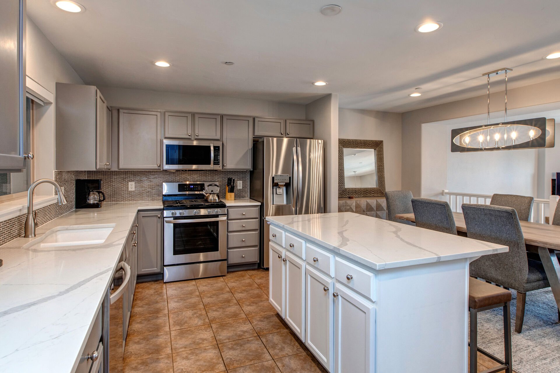 Fully Equipped Kitchen with Granite Countertops, Island Seating for Three, Stainless Steel Appliances, Ample Counter Space and Built-In Ice Maker
