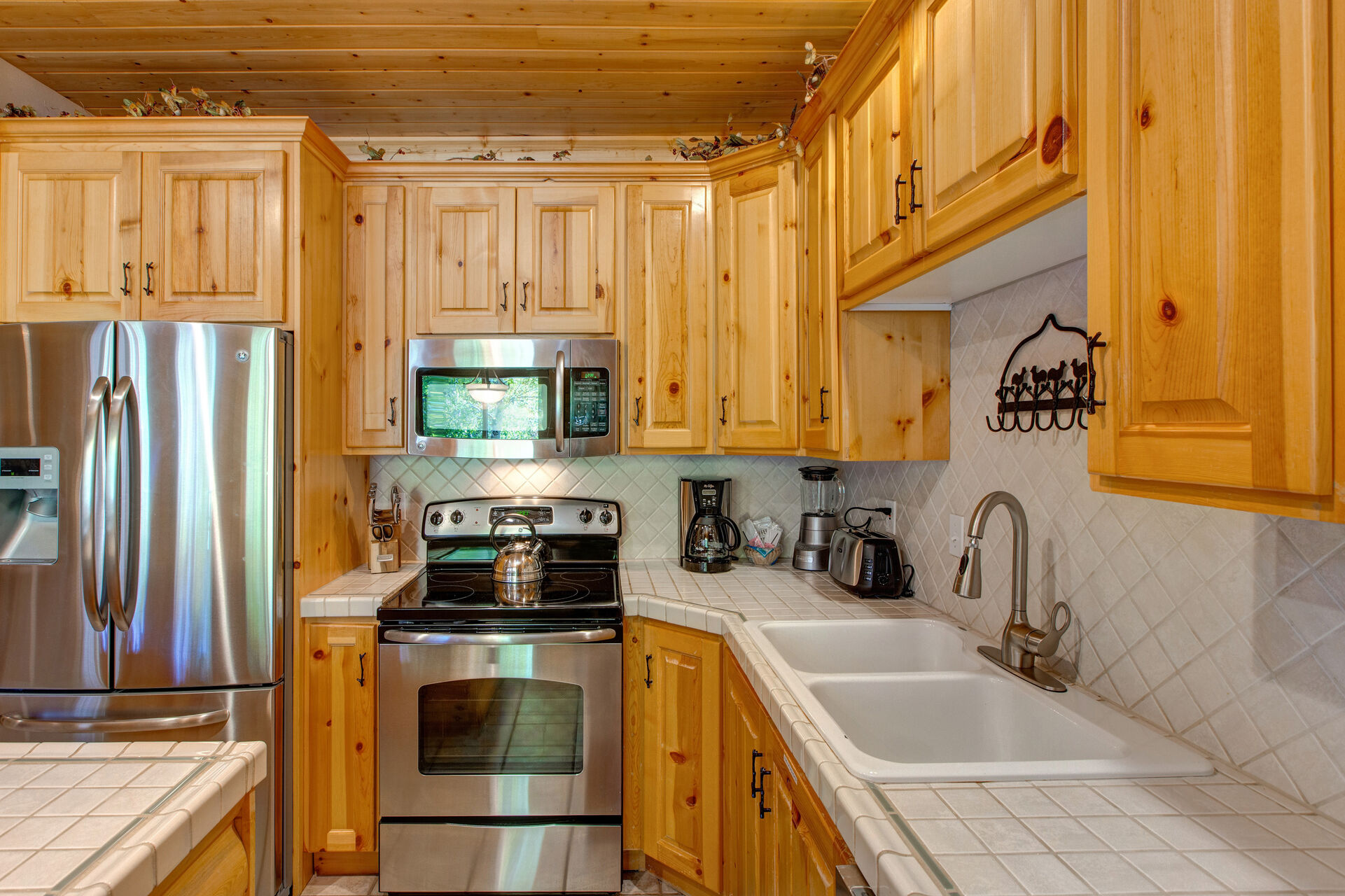 Fully Equipped Kitchen with Stainless Steel Appliances and Tiled Countertops