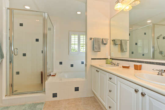 Bathroom with Walk- In Shower, Bathtub, and Double Vanity Sink.