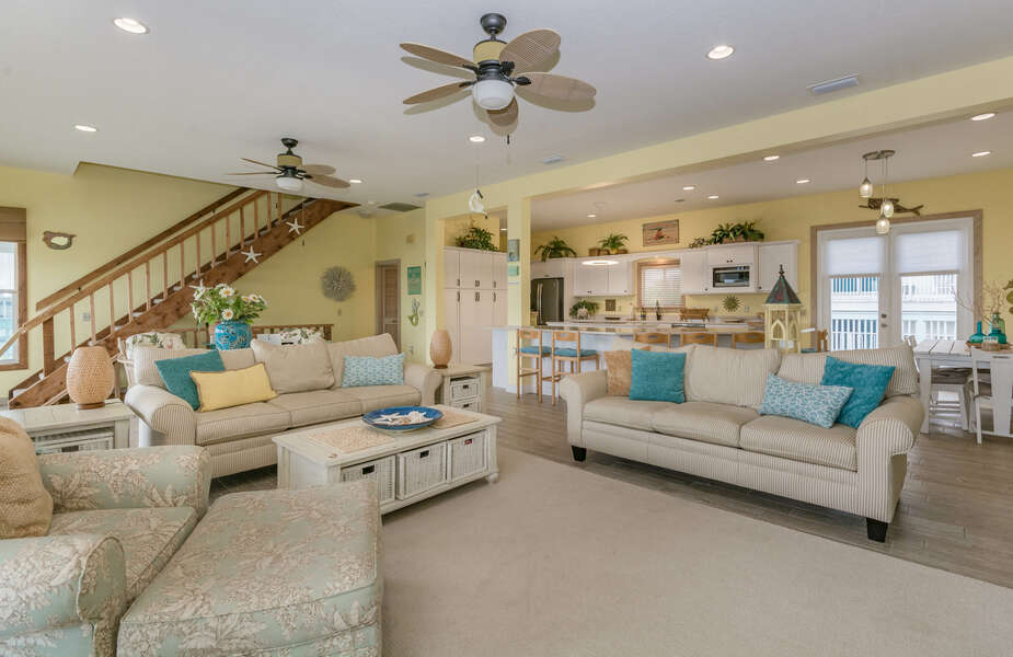 Living room with view into the kitchen area. Two couches with decorative pillows and chair.