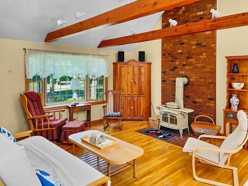 Living area with cozy seating around a hearth and flat screen TV that can be hidden for encouraging conversation - 11 Cranwood Road Harwich Cape Cod New England Vacation Rentals-#BookNEVRDirectAoibhneas
