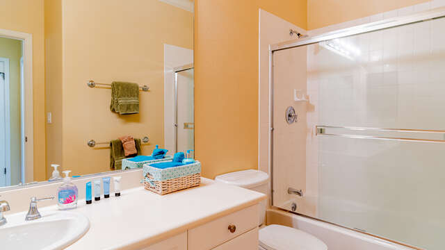 Bathroom in this condo for rent in Ko Olina Hawaii with a toilet, vanity sink, and shower with glass sliding door.
