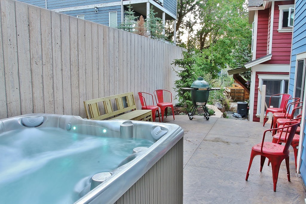 Back yard with heated patio, seating, new 7-seat 100-jet hot tub and a Green Egg Grill