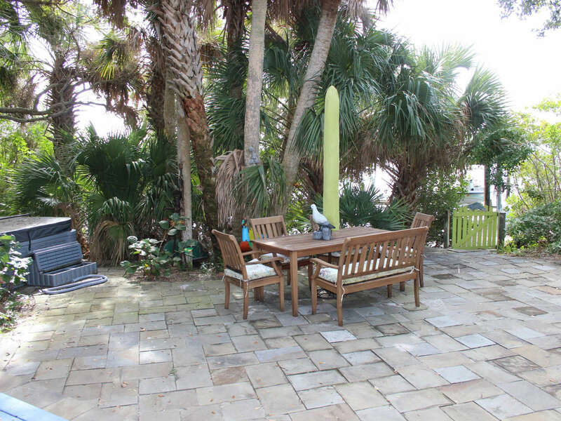 Plush tropical landscaping surrounding the back patio with dining for 6 and fire pit.  HOT TUB NOT AVAILABLE FOR USE.