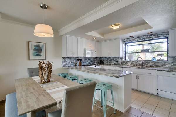 Kitchen & Dining Area, complete with bar seating, dining table, and modern appliances.