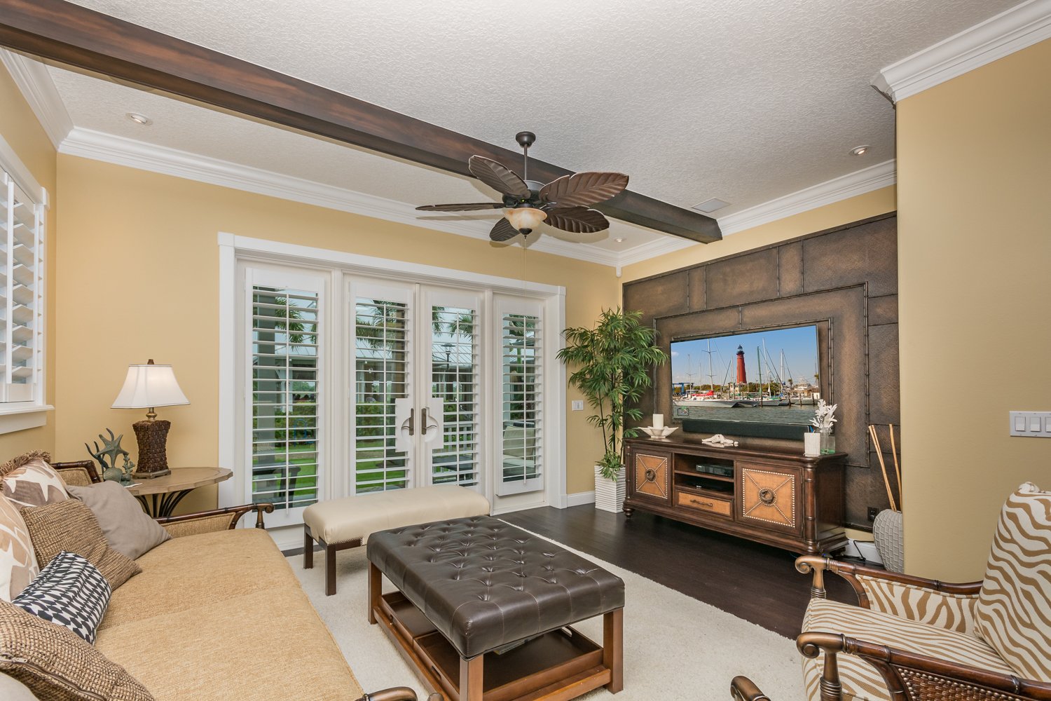 Living room with large flat screen TV, DVD and french doors to covered patio.