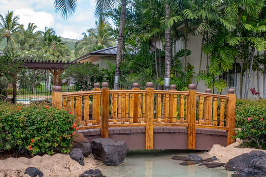 Main Pool Entrance at Coconut Plantation, with a wooden bridge and island landscaping.