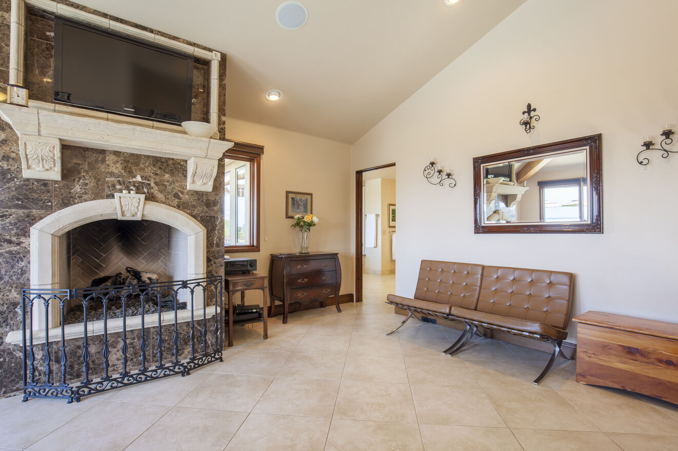 Detailed fireplace and large TV with seating area