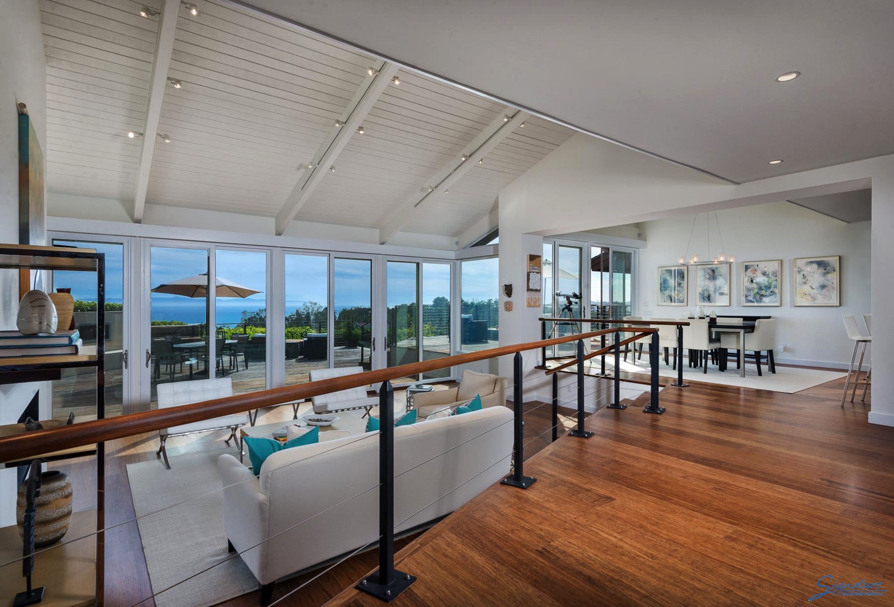 The living room is light and bright with large plate glass windows framing the ocean views.