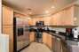 Kitchen w/ grainte counter tops, tile floor and stainless steel appliances.