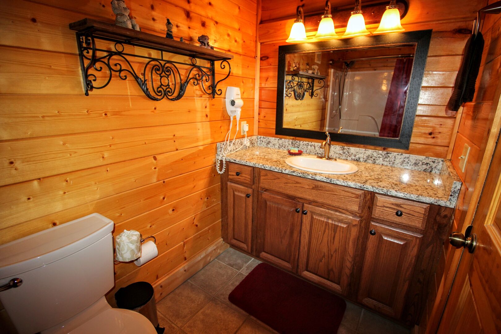 DOWNSTAIRS FULL BATH WITH BLOW DRYER PROVIDED. OAK CABINET & GRANITE COUNTER TOP