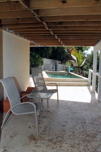 Seating area outside lower level bedroom near the pool