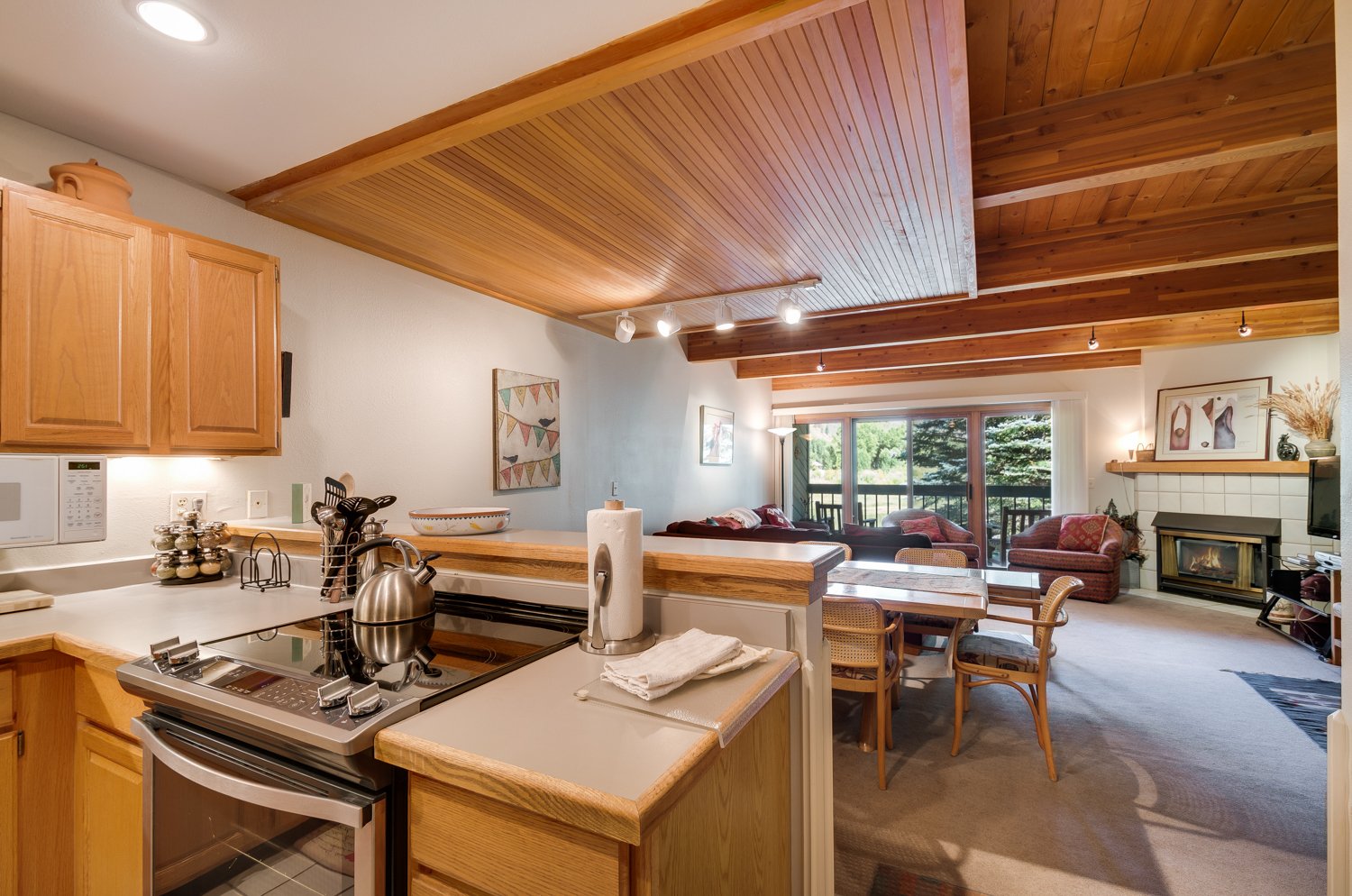 Kitchen to living area view with wood paneling and ceiling