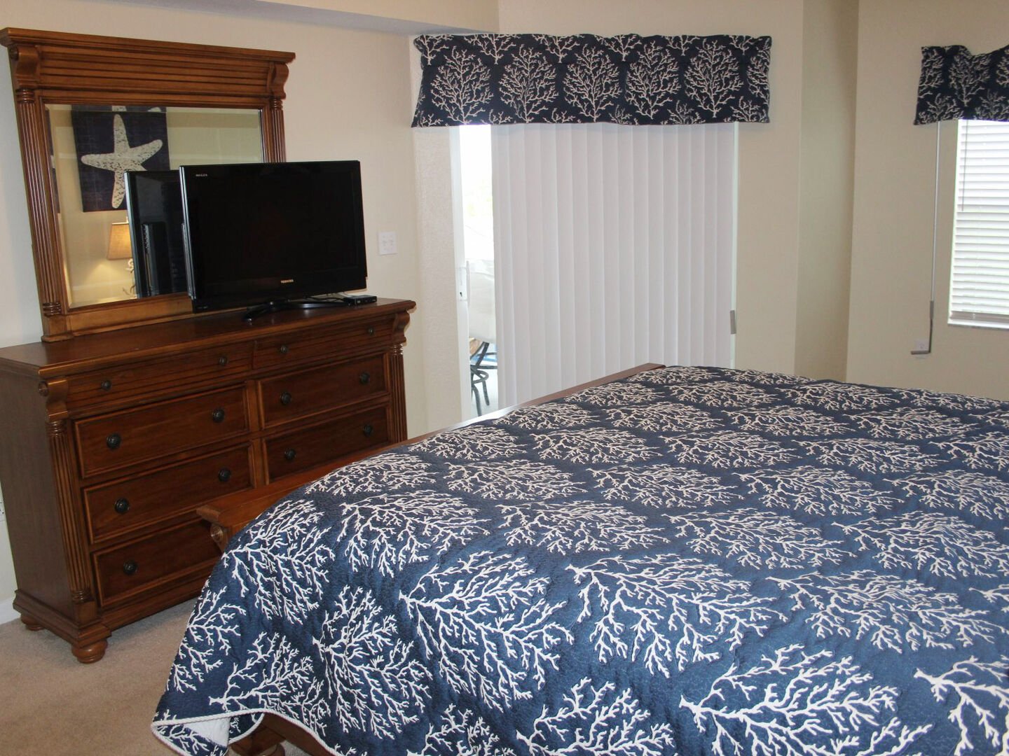 The master bedroom features a flat screen TV, sliders to the patio and walk-in closet.