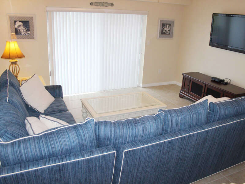 Spacious living room with wrap around couch, large flat screen TV and sliders to private patio.