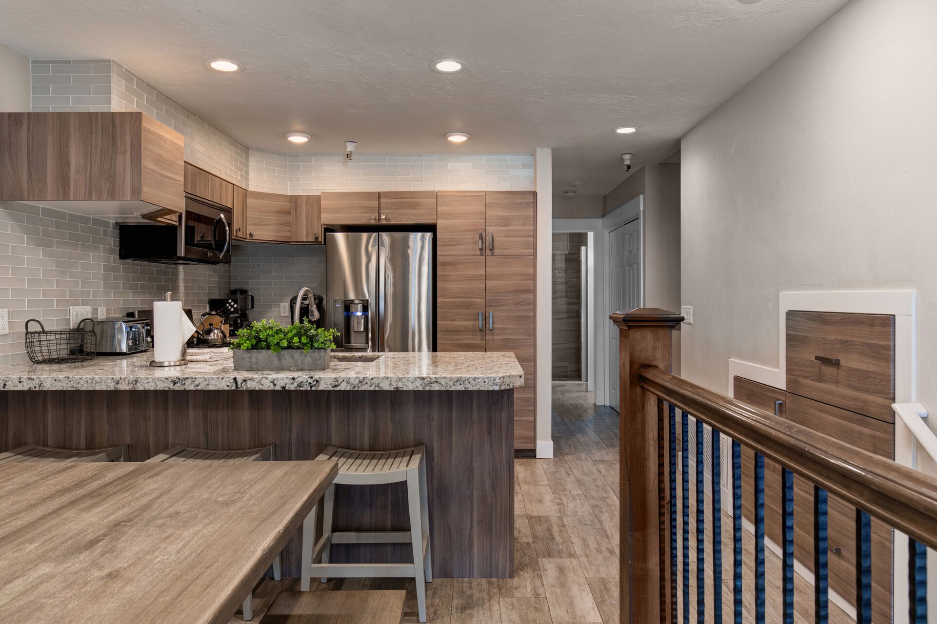 New kitchen with custom cabinets, stainless appliances, 6-burner gas stove, granite counters, and 3 bar seats