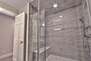Main level hall bathroom with rainwater head tile/stone Euro steam shower and dual raised vessel vanities