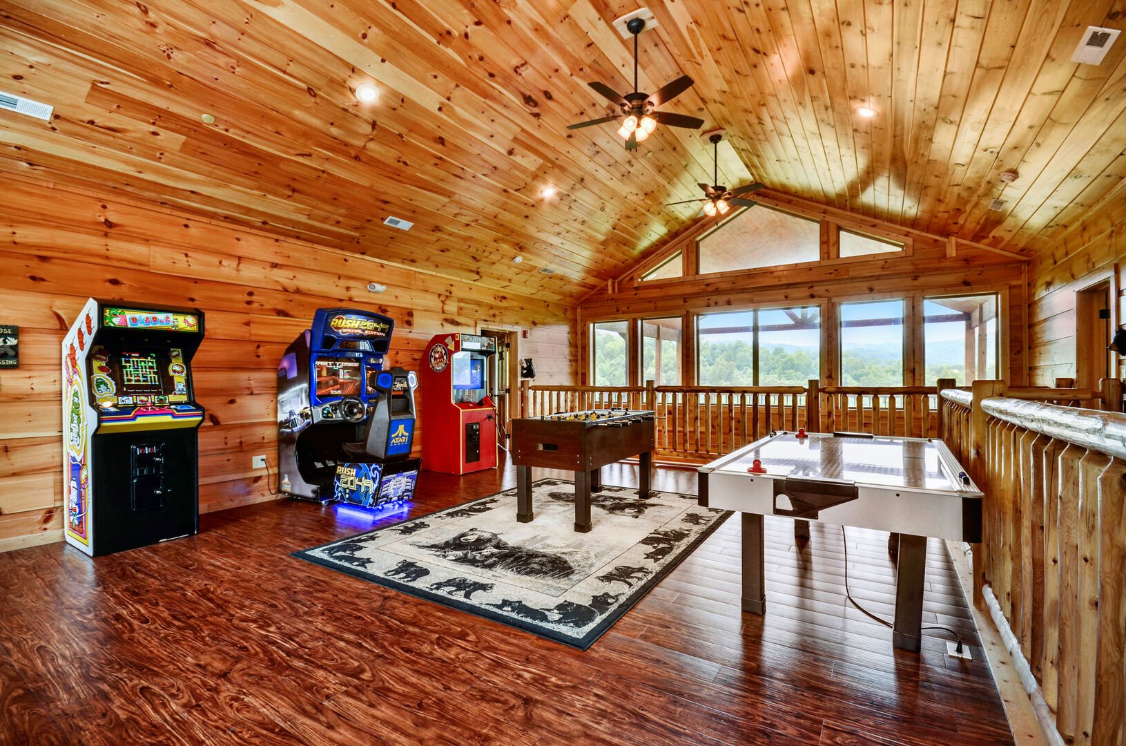 Game room with arcade cabinets and both a foosball and air hockey table on the upper floor of this Vacation rental near Gatlinburg TN.