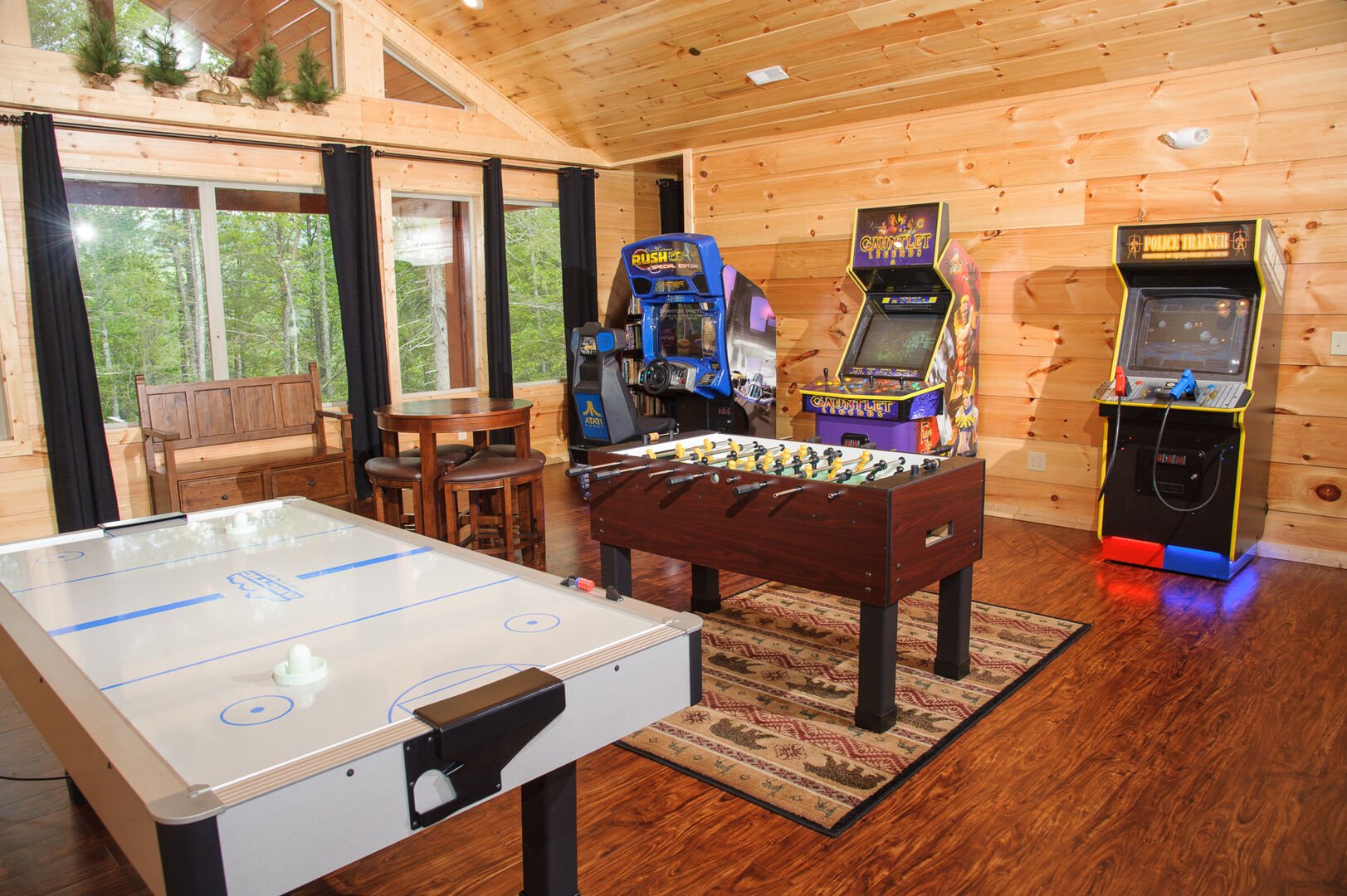 Arcade cabinets, foosball table, an air hockey table of the game room in this Vacation rental near Gatlinburg TN.
