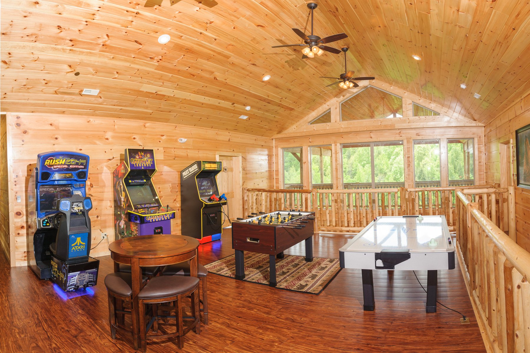 Arcade machines, a foosball table, and an air hockey table highlight the upper floor game room.