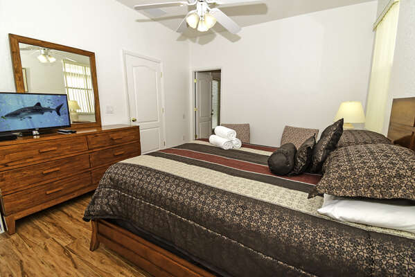 Master bedroom 1 with king size bed, flatscreen TV and en-suite bathroom with pool access