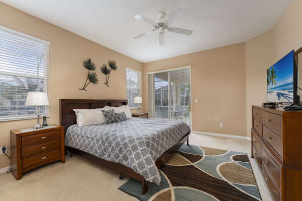 Master suite showing king  bed, TV and pool access