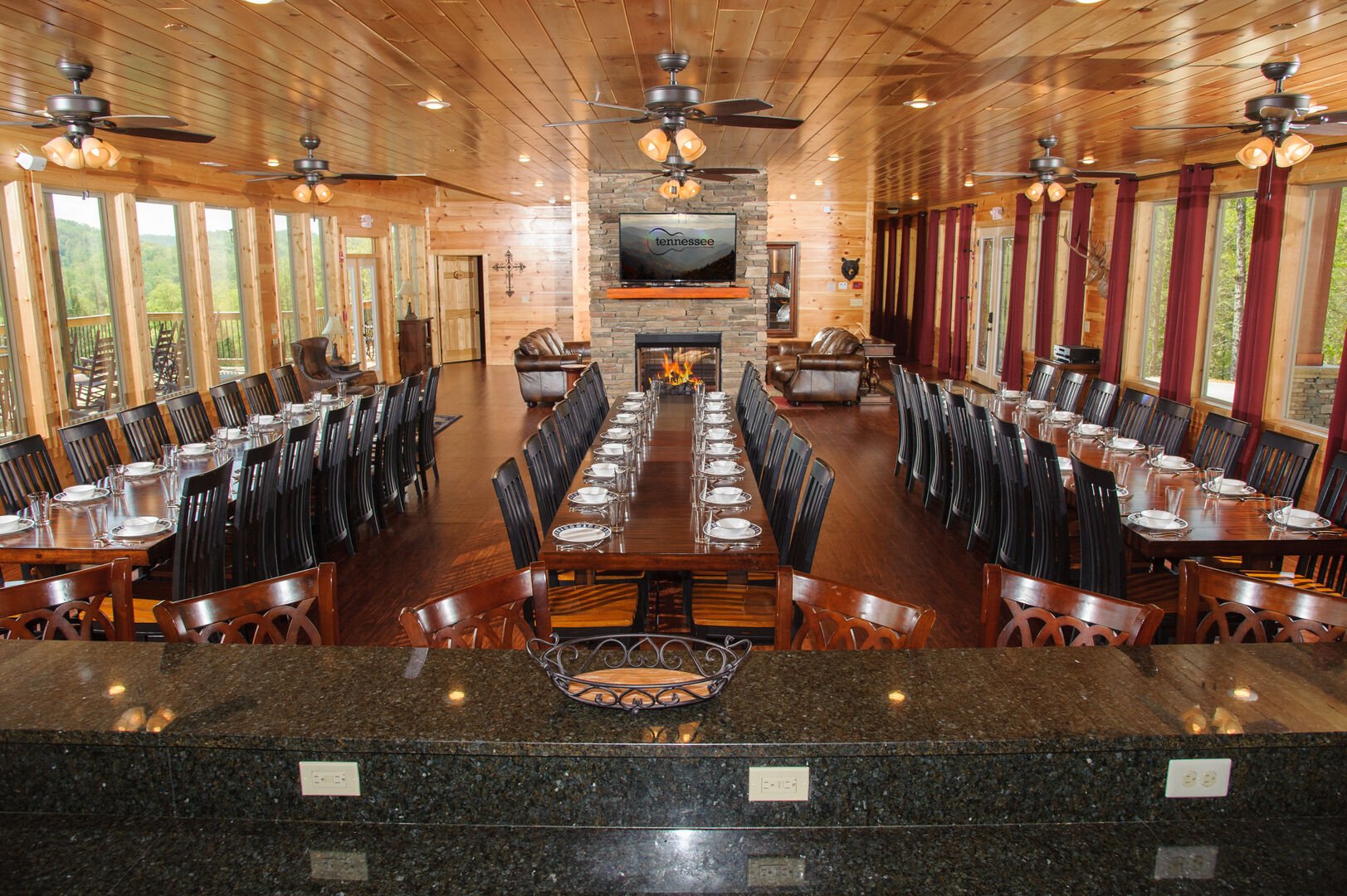Big Dining Room with Tables, Chairs, Fireplace, and TV.