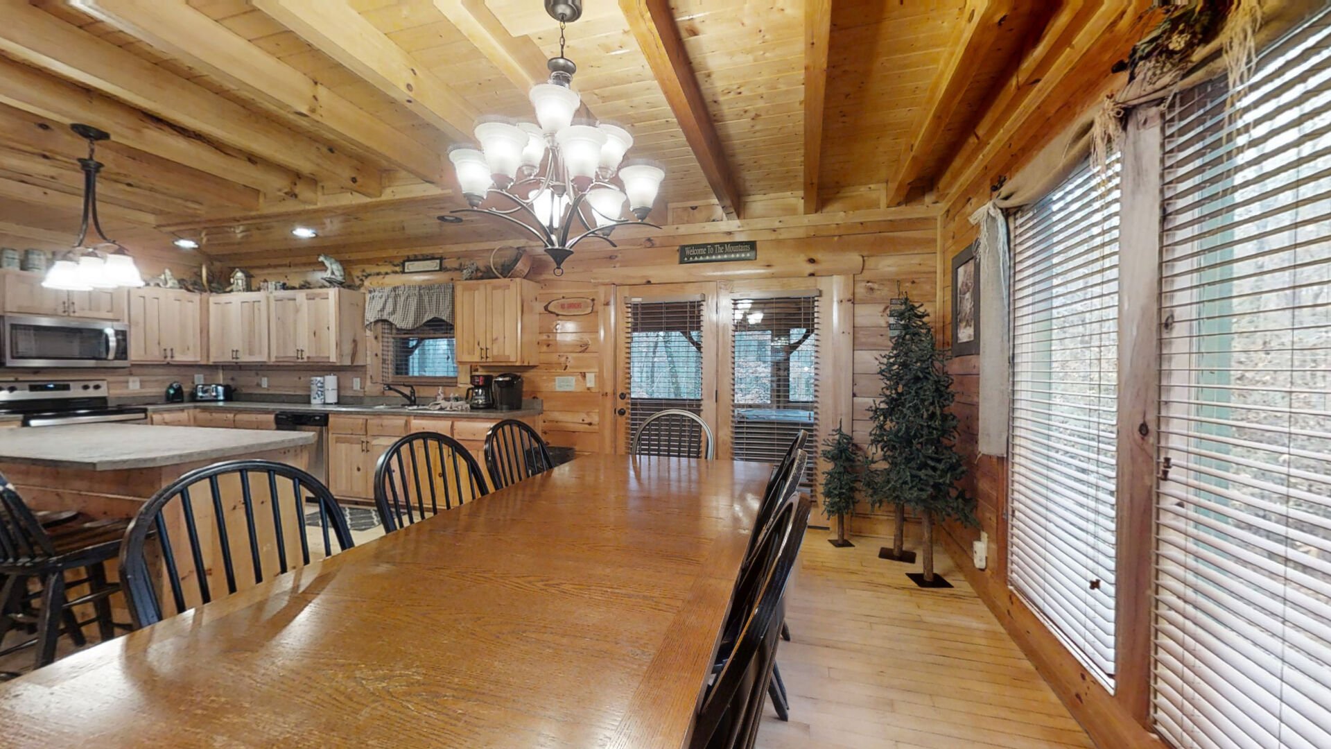 Dining room with large table and seating for eight.  Doors leading out to enclosed screened porch.