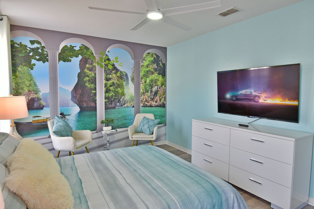 Upstairs bedroom 2showing beautiful mural and seating area and TV