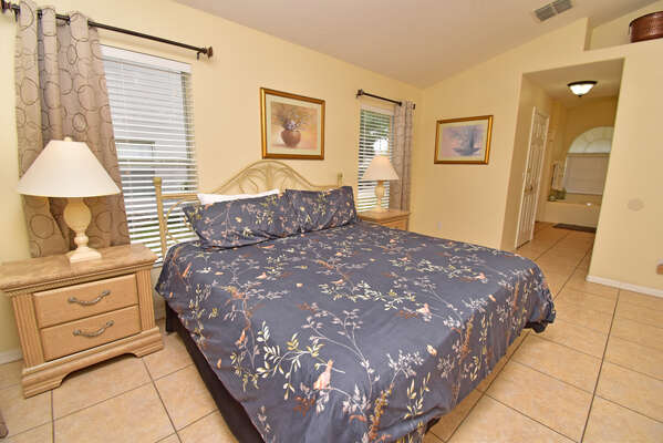Master bedroom has a king bed, wall mounted flatscreen TV, patio doors to the pool and en-suite bathroom